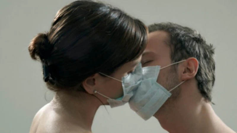 Um casal de máscara se beijando
